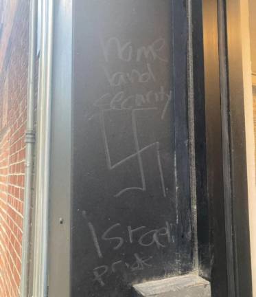 A swastika and other anti-Semitic messages scribbled outside the restaurant (Instagram/2ndavedeli)