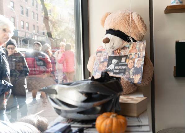 On the bar table next to the entrance, a community of Jewish volunteers setup a blind-folded teddy bear with a poster of children kidnapped by Hamas on Oct. 7. (Priyanka Rajput)