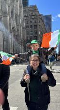 Amanda Brown from New Windsor, NY, gives a lift up Fifth Ave. to her son Cameron, who waves two tri-color flags.