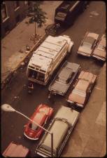 <b>A sanitation truck, seen inching past a row of double parked cars on W. 172nd St. in Manhattan, could soon be less common if the DOT has its way. It seeks public input on where double parking is happening.</b> Photo: Gary Miller, Wikimedia Commons