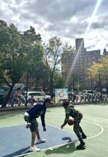 Francisco Alameda, president of Lower East Side Sports Academy, playing basketball with one of the kids in the academy during a festival in Dry Dock Park held as part of Hispanic Heritage Month. Photo: Vanessa Torres