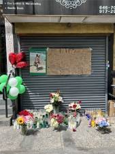A memorial is growing outside the apartment building where beloved Harlem grandmother Excenia Mette was killed on April 22. She was caught in the crossfire by two men fighting on the street near her apartment on Lenox Avenue.