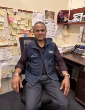 Devindra Jagnanan sits at his desk in the Shipping &amp; Receiving department at the American Museum of Natural History.