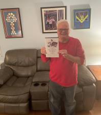 Jimmy Mulzet at home with his book. Photo: Zachary Weg