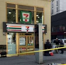 A man was shot and killed during an argument at a 7-Eleven on Eighth Avenue on the morning of Feb. 12, cops say. Shopping bags that could have belonged to the victim can be seen on the sidewalk outside the store, which remained a crime scene hours after the shooting.