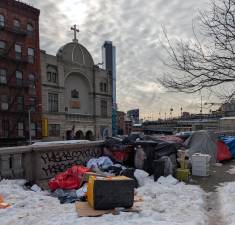 Even in arctic cold, some homeless remained in downtown shantytown, Feb. 6, 2026, with St. Barbara Greek Orthodox Church in the background.