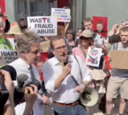 NYS Senator Brad Hoylman-Sigal (left) and Assembly member Michah Lasher (with mic) give speeches at NYC’s Tesla Takedown demonstration that drew hundreds of protestors on March 29 in the West Village. It marked the fifth week of protests at the Tesla showroom.