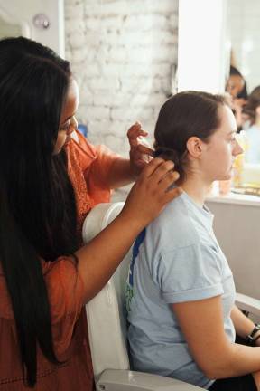 Stylist works on GWC member Lucy Robson's do. Photo: Ryan Segedi  
