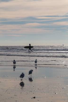 A surfer runs between waves at Rockaway’s Beach 90th Street in mid-November.