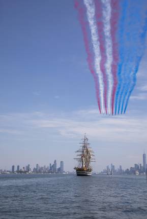 A view of BAE Hawk jets leaving vapor trails of the U.S. flag above the Manhattan skyline above the Italian tall ship, Amerigo Vespucci.
