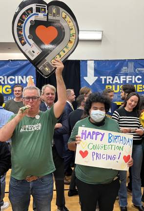 Before the start of the Congestion Pricing Meeting at the McBurney YMCA, on Jan. 5, two enthusiastic members of the Riders Alliance showed off their tokens of advocacy.