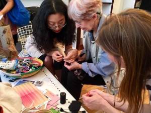 Caroline Zhang (left) demonstrates hand-stitching repair at Mending Lab.