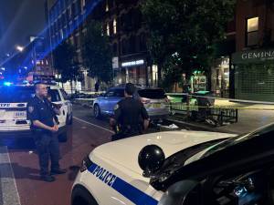 Police on E. 14th St. in July, after a violent encounter left one person dead and two others stabbed.