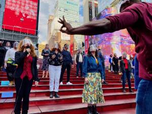 Maryam Banikarim of NYCNext said “it was hard not to cry” at their Broadway event where Bernadette Peters (bottom left) and others sang on the TKTS steps. Photo courtesy of NYCNext