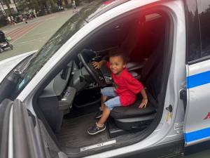 A youngster sits in the front seat of a police cruiser and gets to sound the siren at the National Night Out event staged by the 19th Precinct at St. Catherine’s Park on the UES.