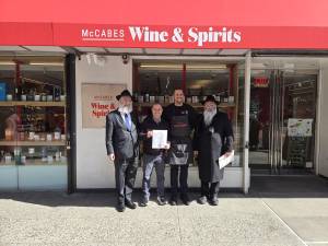 Despite the shops Celtic sounding name, McCabe’s Wine &amp; Spirits is a kosher liquor store owned by an observant Jewish proprietor Daniel Mesnik who must sell the store for the duration of Passover and then buy it back. From left: Rabbi Ben Krasnianski, Daniel Mesznik, Allen Alexis, Rabbi Kalman Weinfeld