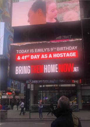 <b>Thomas Hand, seen here gazing at a Times Square billboard that showed his daughter Emily on her ninth birthday which was spent as a hostage in Gaza. She was among the hostages freed over the weekend.</b> Photo: Keith J. Kelly