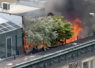 A fire on the roof of 366 Broadway blazing on the morning of June 19, visible to passerby and nearby buildfing occupants.