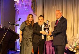 Rabbi Shmuel Metzger (center) and his wife Raizy Metzger (left) present the Builders Award at the Chabad Sutton gala to Michael Hershman, CEO of the Soloviev Group.