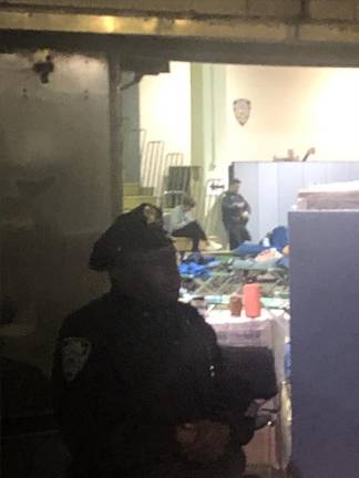 <b>Cots are visible in the background at the former NYPD Academy that is now converting the first floor gym into emergency housing for newly arrived immigrants as city deals with a new wave of asylum seekers being bused in from Texas.</b> Photo: Keith J. Kelly