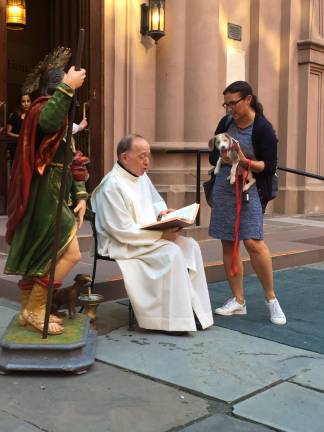 The Rev. Monsignor Donald Sakano, next to the statue of St. Rocco, at The Basilica of Saint Patrick's Old Cathedral for the Blessings of the Dogs. Photo: Estelle Pyper