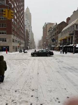 A car cautiously makes its way through a snow-blown intersection on the UES on Jan. 25.