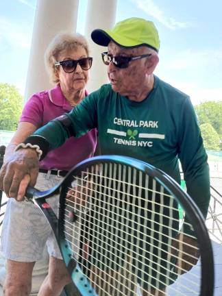 Langley Danowitz gets a hands-on grip lesson from Yale Lang, a 91 1/2 year old tennis player who was once a tennis coach. He can be found on the Central Park tennis courts almost every weekday.