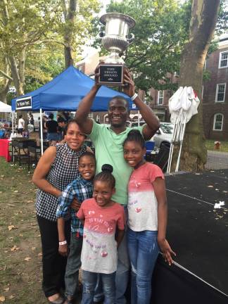 Godshelter and Bisola Oluwalogbon, along with their three children, with the the Vendy Cup, the top honor in the annual street food competition put on by the Street Vendor Project. Photo: Carson Kessler