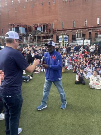 Mookie Wilson gets ready to address the crowd, taking mic from PSLL president Nick McKeon on March 29 at Con Ed field as the league kicks off its 75th season.