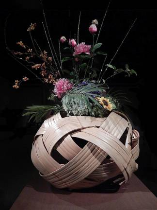 "Dragon in the Clouds Flower Basket" by Iizuka Shokansai holds an ikebana floral display created by the Ikebana International New York Chapter. Photo: Adel Gorgy