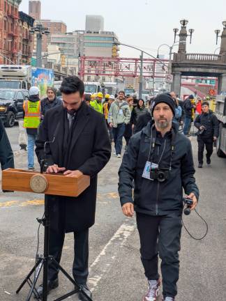 A journalist walks past Mayor Mandami prior to Williamsburg Bump address.