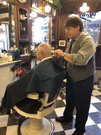 H&eacute;ctor Masner puts the finishing touches on a haircut at York Barber Shop. An An old-school aesthetic prevails at the Lexington Avenue shop. Photo: Shoshy Ciment