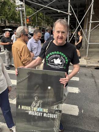 John McDonagh, who co-hosted the <i>Radio Free Eireann</i> show on station WBAI with Malachy McCourt, shows off the poster of McCourt’s bestselling memoir, <i>A Monk Swimming. </i>The poster became the “passenger” in the back seat of a horse-drawn carriage that made its way down West 93rd Street to the corner of West End Avenue for the ceremony.