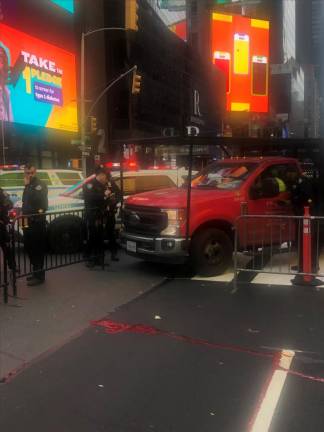Police officers write summons after driver of Ford truck struck a pedestrian walking across Times Square. Blood from the victim, who was pronounced dead at Bellevue Hospital, can be seen on the street. Photo: Keith J. Kelly