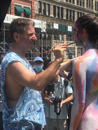 Andy Golub (left), the founder of the annual body painting art show paints first time model Alyssa Swartz at what he says is the final exhibit celebrating the human body as art form.