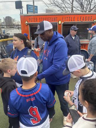 Former Mets great Dwight “Doc” Gooden signs autographs for young fans. He joined former teammates Mookie Wilson and Daryl Strawberry from the 1986 World Champion Mets at the opening day festivities of the Peter Stuyvesant Little League.