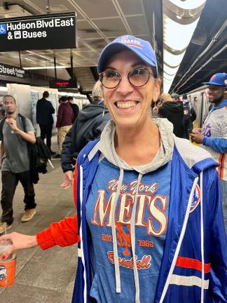 A well-attired Lisa Daglian of Queens displayed her Mets colors from jersey to beverage container to earrings with a wide smile as she disembarked from NYC Transit’s first-ever Opening Day nostalgia train to Citi Field.