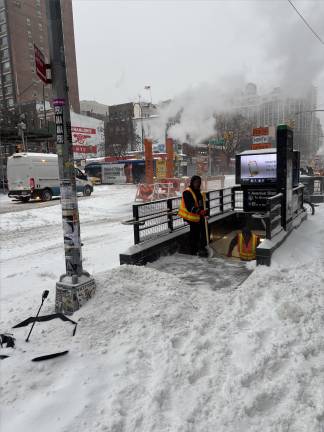 Workers clear the entrance to the L line at 1st Ave. and E. 14th St.