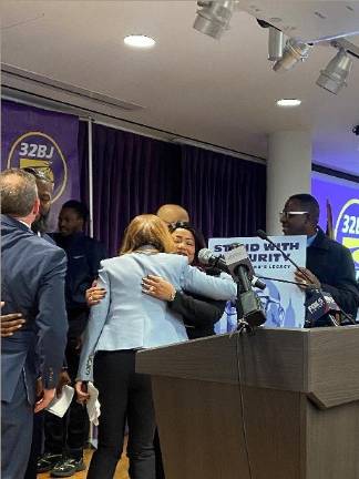 Julie Menin hugs Rachel Paoli the longtime partner of Aland Etienne and mother of their now seven year old son, after a press conference to herald passage of a bill named in honor the slain security guard, He was one of four killed by a crazed gunman in a mass shooting in mid-town last July.