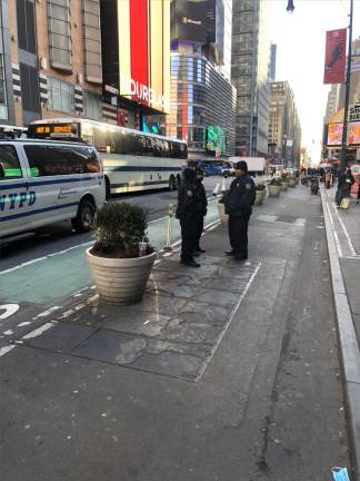 Cops gather near the corner of Eighth Ave. and 43rd St. on Feb. 10, near the spot where a 22 year old man fell after being shot a block away outside a Shake Shack a day earlier. Two suspects remain at large. Photo: Keith J&gt; Kelly