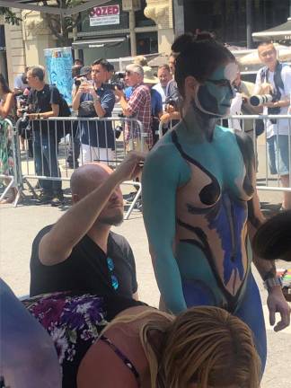 Artist Patrick Lawless (left) paints model Kim Sarosky (right) at the final body painting show in Union Square on July 23.