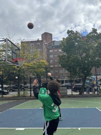 Kids in LES Sports Academy playing basketball at the festival.