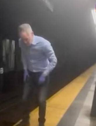 Matthew Tirschwell, an off duty EMT, gets ready to leap onto the tracks at the E. 86th St. subway station to save the life of a victim who had fallen onto the tracks and had his leg amputated.