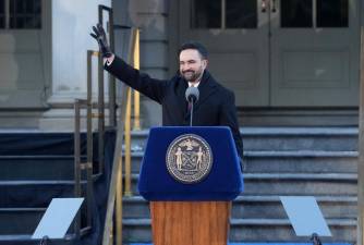Zohran Mamdani waves to supporters as he prepares to deliver his inauguration address from the steps of City Hall on Jan. 1.