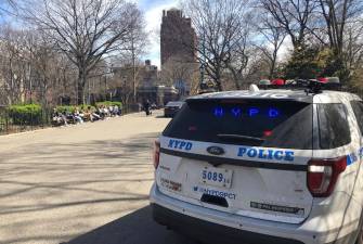 A patrol car from the Ninth Precinct keeps watch in Tompkins Square Park on March 17, a day after two residents were wounded by stray bullets fired by an unknown gunman. The victims were not believed to be the intended targets. The same unknown gunman is believed to be connected to a second shooting five days later. Photo: Keith J. Kelly