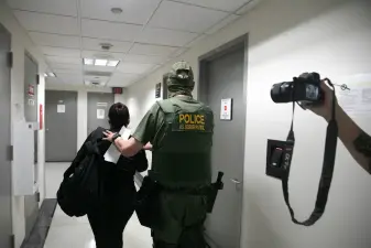 A U.S. Border Patrol agent is seen detaining a woman within the Federal Plaza immigration courthouse Aug. 7, 2025.