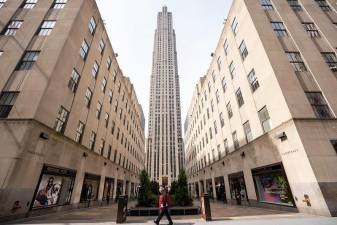 A commuter sporting latex gloves passes by Rockefeller Center, March 18, 2020.