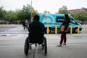 People enter and leave Elmhurst Hospital in Queens, May 22, 2025.