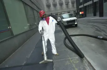A worker vacuums up debris in downtown Manhattan on Sept. 15, 2001 after the September 11 terrorist attacks on the World Trade Center in New York City.