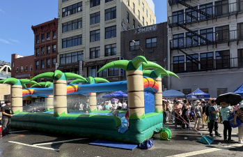 Children enjoy the water-soaked bouncy castle on Division Street, set up for the 5th Precinct and the Chinese Chamber of Commerce’s annual National Night Out (NNO) event.